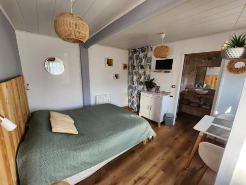 a bedroom with a green bed and a desk at Les chambres du Bonheur in Fontaine-sous-Jouy