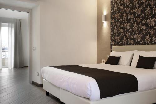 a bedroom with a large bed with a black and white blanket at Hotel Ponti in Angera