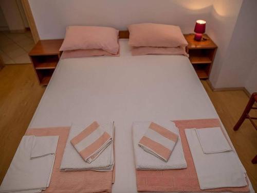 a large white bed with two pillows on it at Apartman Zenta in Petrovac na Moru