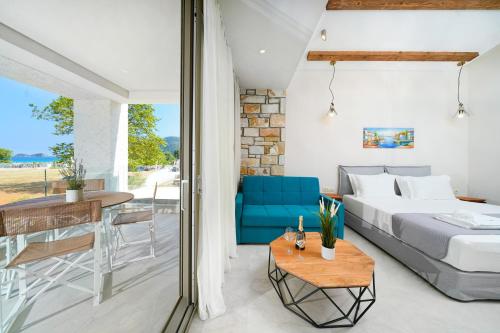 a bedroom with a bed and a table with a blue chair at Brothers Studios & Suites in Skala Potamias