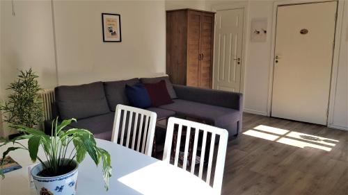a living room with a couch and a table and chairs at Parkvillan Sunshine Living Condo in Koppom