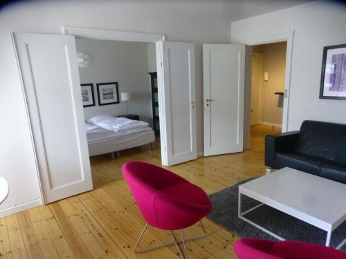 uma sala de estar com uma cadeira vermelha e um sofá em Christianshavn Apartments 536 em Copenhaga