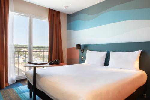 een hotelkamer met een bed en een raam bij Ibis Styles Miramas in Miramas
