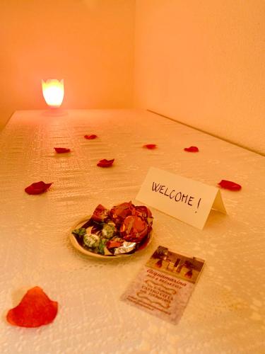 a plate of food on a bed with a welcome sign at Bed & Breakfast Acquamarina in Castro di Lecce