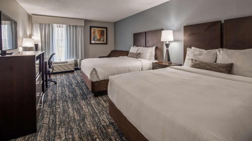 a hotel room with two beds and a television at Best Western Inn Florence in Florence