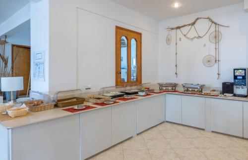 a large kitchen with white cabinets and a counter top at Argo Hotel in Amoopi