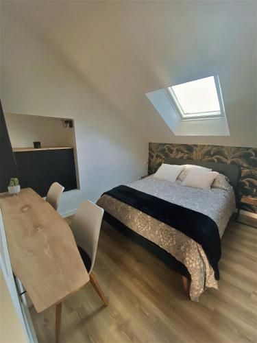 une chambre avec un lit et une lucarne dans l'établissement Gîte La Terrasse du 37, à Breteil