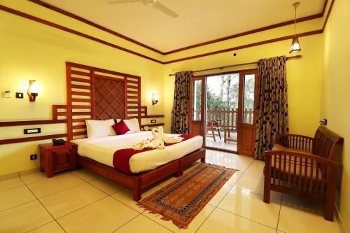 a bedroom with a bed and a balcony at ELEPHANT ROUTE in Thekkady