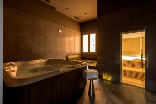 a large bathroom with a tub and a window at Cora Hotel in Split