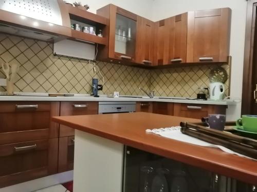 a kitchen with wooden cabinets and a wooden counter top at La casa di Lo, marina di Sorso in Sorso