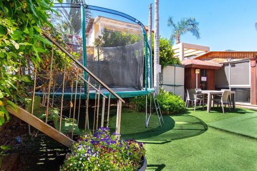a garden with a swing in a yard at Nof glili Mansion in Yavneʼel