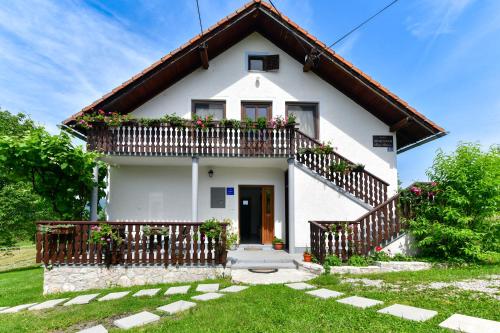 Casa blanca pequeña con balcón en Apartman PLUM PLITVICE en Drežnik Grad