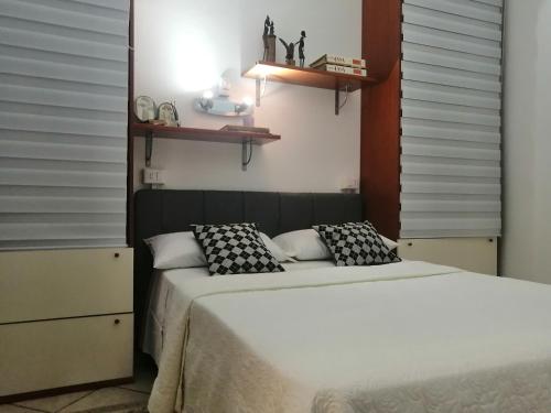 a bedroom with two beds and shelves on the wall at La casa di Lo, marina di Sorso in Sorso