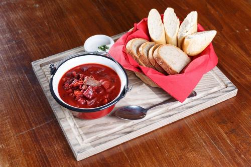 a tray with a sandwich and a bowl of chili and bread at Penzion U Kriveho psa in Frýdek-Místek