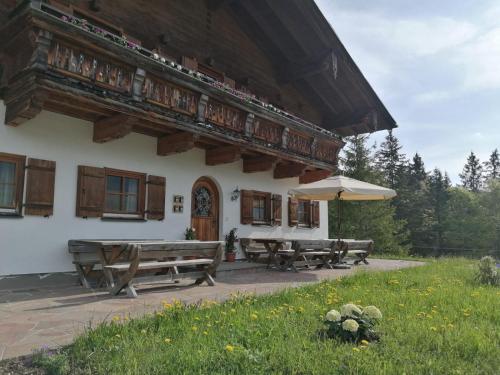a building with picnic tables and an umbrella at Haus Obweg - Postalm in Hallein