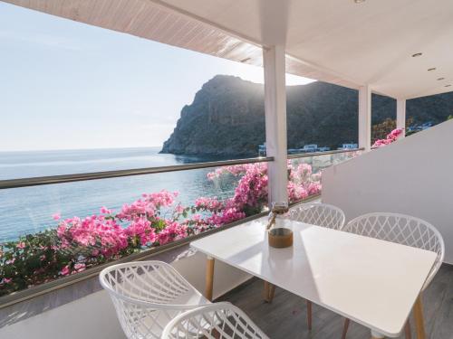 una mesa y sillas blancas con vistas al océano en Zorbas Apartments-Am Strand von Lentas, en Lentas