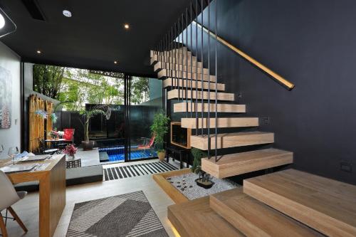 a staircase in a living room with a table at Villoft Zen Living Resort in Thalang