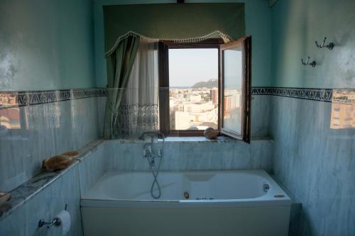 a bath tub in a bathroom with a window at Prestigioso Attico Panoramico Cagliari in Cagliari