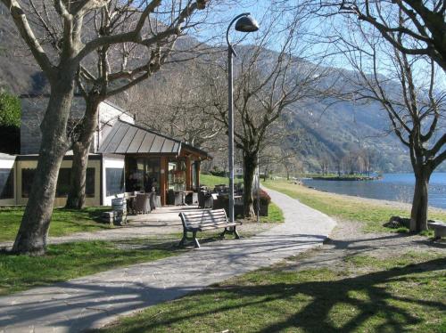 a park bench next to a street light and a building at La Rosa e la Spina - Casa Vacanze indipendente con giardino privato - Dervio, Lago di Como in Dervio