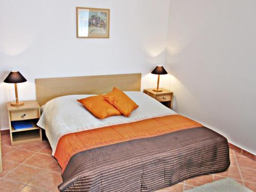 a bedroom with a bed with orange pillows on it at Süle Apartments & Rooms in Balatonfüred