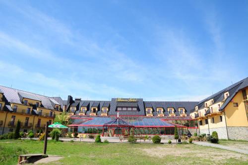 a large building with an umbrella in front of it at Manor Hotel in Olsztyn