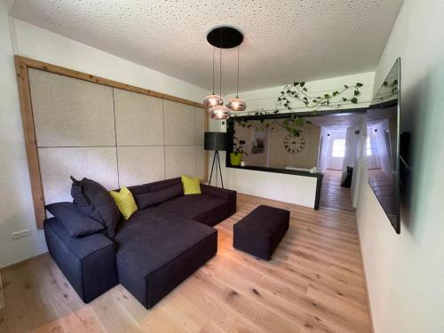 a living room with a couch and a television at Villa Sonnenwinkl - Reith bei Seefeld in Reith bei Seefeld