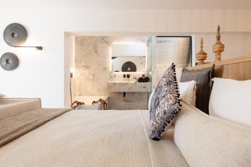 a bedroom with a bed with a couch and a mirror at Athina Studios and Suites Plaka in Plaka