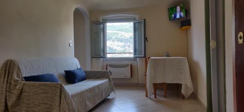 - un salon avec un canapé, une table et une fenêtre dans l'établissement Dolce Vita Alta Ventimiglia, à Vintimille