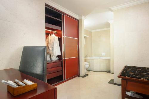 y baño con armario rojo, aseo y lavamanos. en Swiss-Belhotel Tarakan, en Tarakan