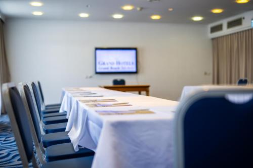 a conference room with a table and chairs and a screen at Grand Beach Hotel in Tel Aviv