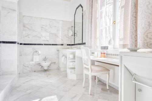 a white bathroom with a sink and a desk at Wald & Schlosshotel Friedrichsruhe in Friedrichsruhe