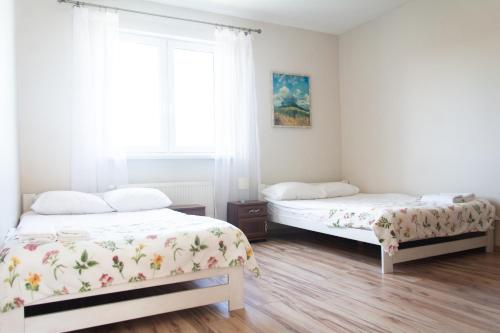 a bedroom with two beds and a window at Babie Lato in Mrągowo