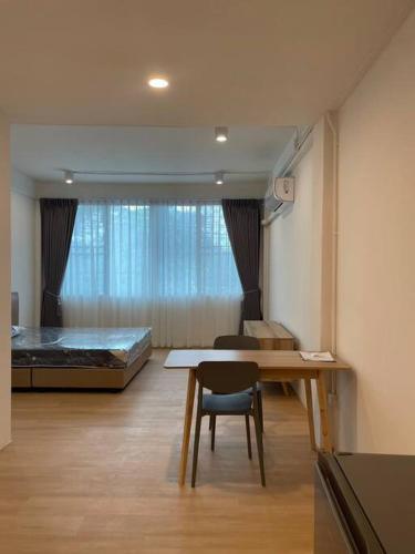 Cette chambre comprend un lit, une table et un bureau. dans l'établissement 33 Avenue, à Bangkok