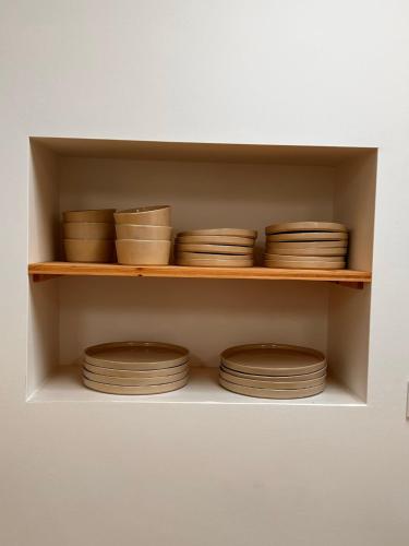 a shelf filled with brown bowls and plates at Palmeirinha Guest House in Sintra