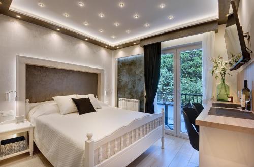 1 dormitorio con cama blanca y balcón en Apartments Zanetti, en Pula