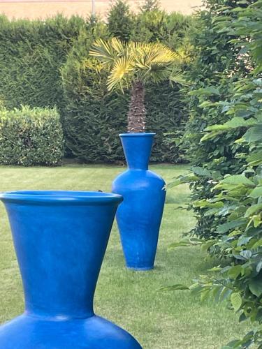 two blue vases sitting on the grass in a yard at B&B 1001 nacht in Zonhoven