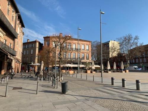 une rue de la ville avec des bâtiments et un arbre au milieu dans l'établissement Elégant T2 Proche Cathédrale Centre Historique, à Albi