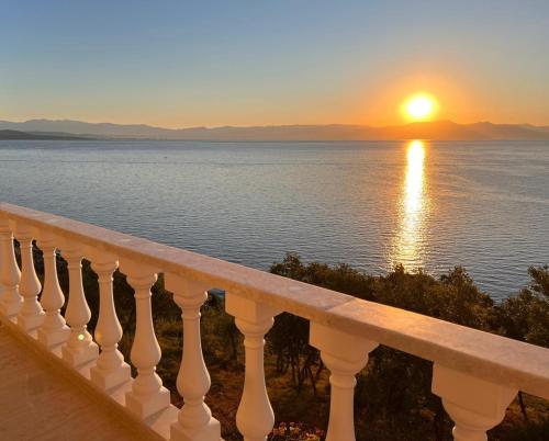 a view of the ocean from a balcony at sunset at Villa Big Blue in Mavrovoúnion