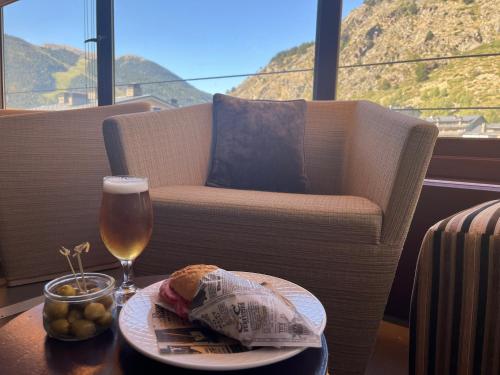 a table with a plate of food and a glass of wine at Wuau! Hotel Galanthus & Spa in Soldeu