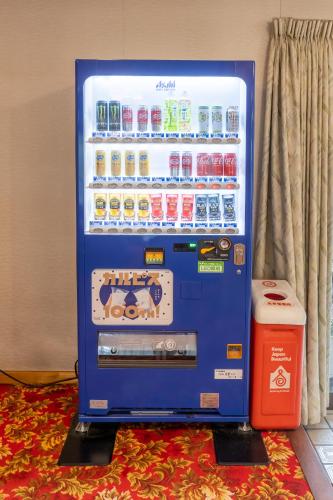 a blue soda vending machine sitting on a rug at 檜湯の宿　松伯 in Aoki-gemi