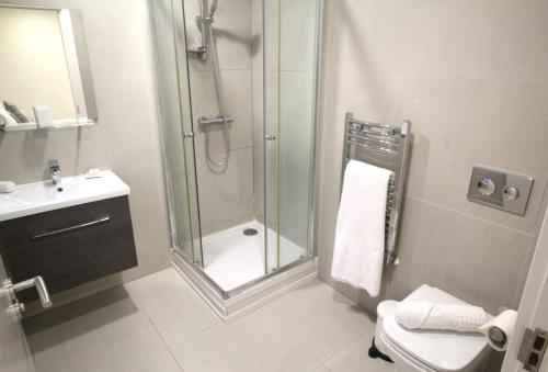 La salle de bains est pourvue d'une douche, de toilettes et d'un lavabo. dans l'établissement 3 Bed Cozy Apartment - next to Leeds City Centre & University, à Headingley