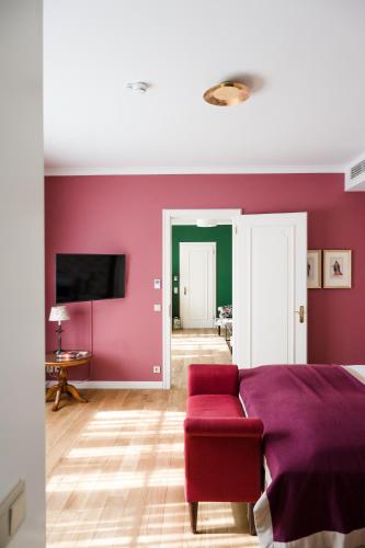 a bedroom with a purple bed and a red couch at Wald & Schlosshotel Friedrichsruhe in Friedrichsruhe