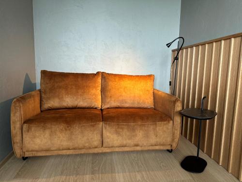 a brown couch in a living room with a lamp at Park Hotel Tornio in Tornio