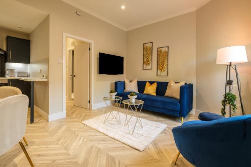 a living room with a blue couch and a table at West End Retreat - SJA Stays - 2 Bed Apartment in Aberdeen