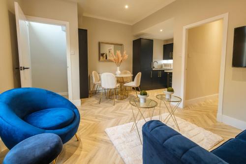 a living room with a blue couch and a table at West End Retreat - SJA Stays - 2 Bed Apartment in Aberdeen