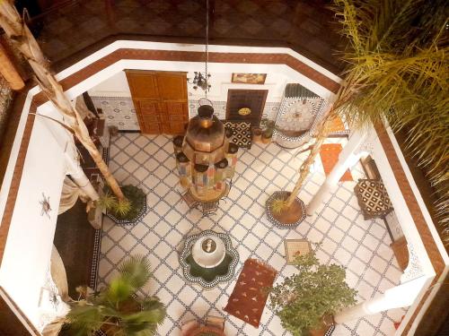 - une vue sur la terrasse agrémentée de plantes en pot dans l'établissement Riad Chennaoui, à Marrakech