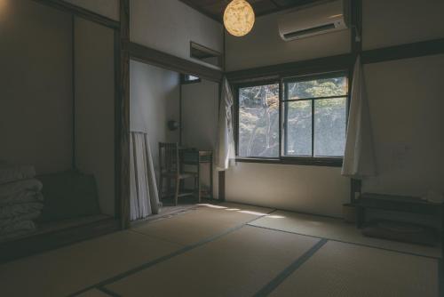 een lege kamer met een raam en een kamer met een vloer bij Nari Nuttari Nari in Niigata