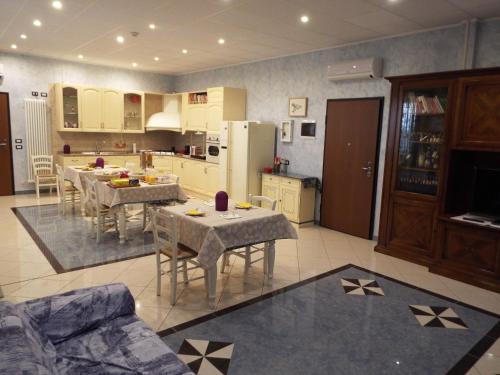 a kitchen and dining room with tables and a refrigerator at B&B Il Portico in Praticello di Gattatico