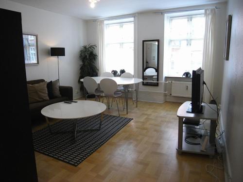 a living room with two tables and a tv at Nørrebro Apartments 591 in Copenhagen