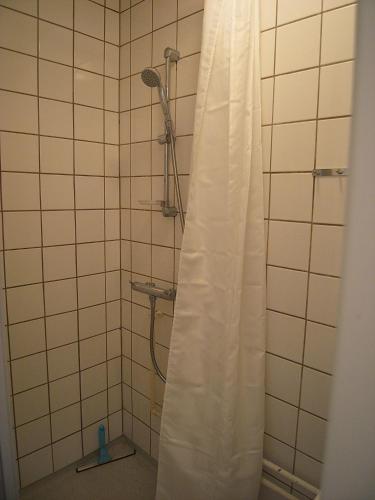 a shower with a white shower curtain in a bathroom at Nørrebro Apartments 591 in Copenhagen